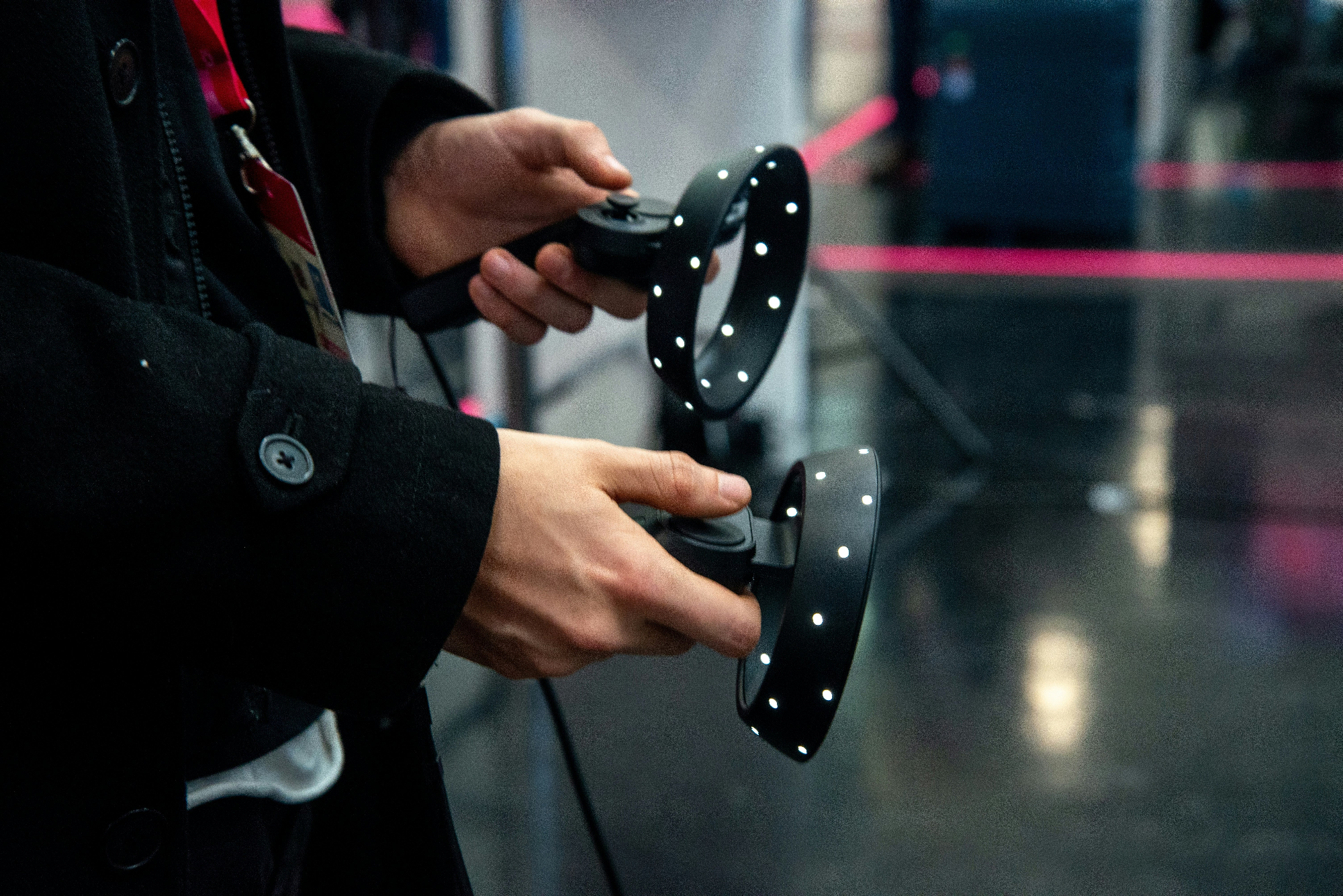 Hands holding two LED-studded wireless tracking controllers